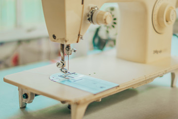 Closeup of an old lady's hand working sewing clothes on sewing machine