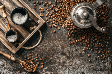 Obraz na płótnie Canvas Coffee on wooden tray with coffee beans on dark textured background. Top view with copy space. Background with free text space.