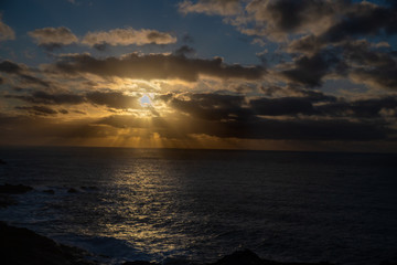 Sun rays behind cloud at sunset cloudscape seascape in Cornwall