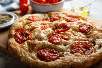 Bari-style focaccia bread, focaccia barese, focaccia with cherry tomatoes, olive oil and oregano.