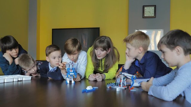 Kids creating figures with teacher. Early development, modern technology concept