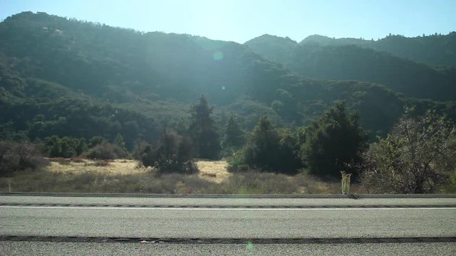 Really fast red sports car speeding by camera quickly on a beautiful mountain road.
