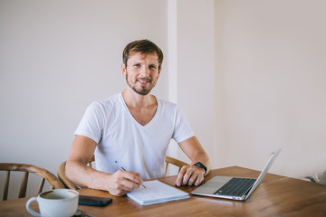 Interested young man working on laptop at home