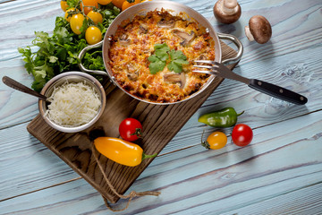 Pieces of chicken breast baked with mushrooms and cheese close-up.