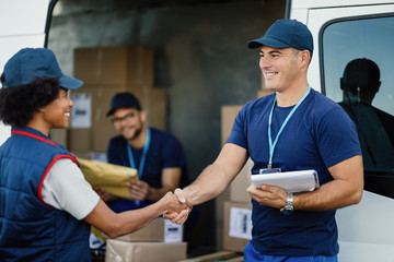 Happy delivery man shaking hands with his female coworker.