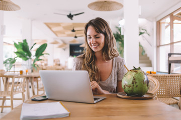 Cheerful woman in casual wear creating excited article with information about tropical fruits...