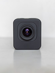 Action-camera with a glass lens on the surface of the white table