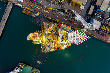 Aerial view of a jack up oil drilling rig and dry dock ship in the shipyard for maintenance during...