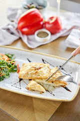 Woman eats Latin American fried empanadas with Vegetable salad with arugula. Decorated with balsamic sauce. Menu restaurant