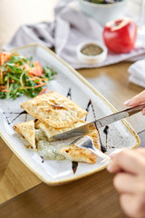 Woman eats Latin American fried empanadas with Vegetable salad with arugula. Decorated with balsamic sauce. Menu restaurant