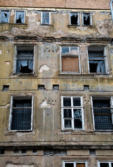 Old Desolate Apartment House With Damaged Facade And Bursted Windows