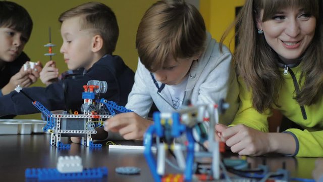 Kids creating figures with teacher. Early development, modern technology concept