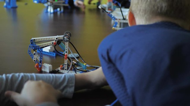 Kids creating figures with teacher. Early development, modern technology concept