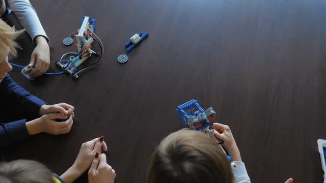 Kids creating figures with teacher. Early development, modern technology concept