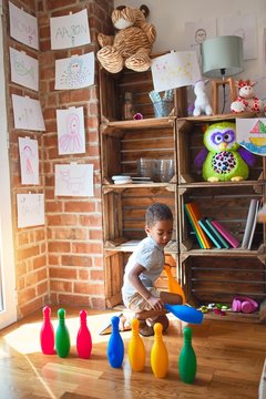 Beautiful african american toddler taking skittles to play bowling at kindergarten