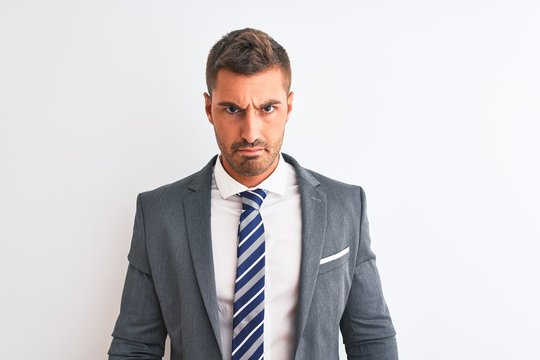Young handsome business man wearing suit and tie over isolated background Relaxed with serious expression on face. Simple and natural looking at the camera.