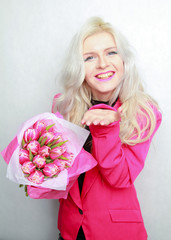 tender pretty blonde slim teen girl with pink flowers. cheerful woman with fresh bouquet