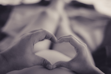 heart made of hands on pregnant belly, pregnacy background