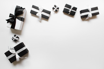 Many birthday holiday gift presents wrapped in black and white paper with black and white satin...