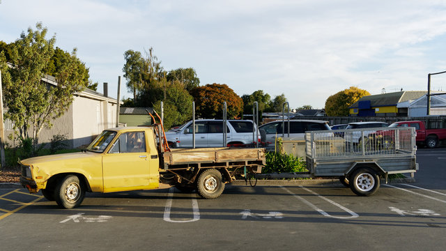 A pick up truck and trailer parked across three push chair and baby parking bays.