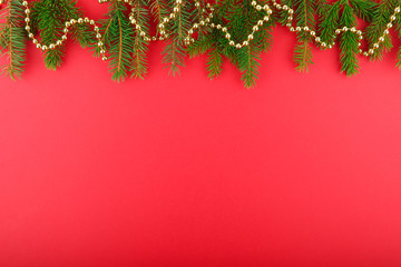 decorated Christmas tree branches on a red background with copy space. christmas background with natural christmas tree