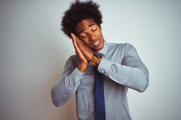 American business man with afro hair wearing shirt and tie over isolated white background sleeping tired dreaming and posing with hands together while smiling with closed eyes.