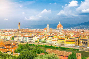Fototapeta na wymiar Top aerial panoramic view of Florence city with Duomo Cattedrale di Santa Maria del Fiore cathedral, buildings houses with orange red tiled roofs and Arno river, blue sky white clouds, Tuscany, Italy