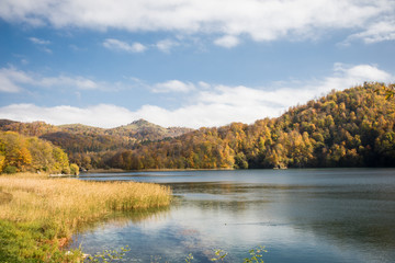 A calm evening landscape with lake and mountains. Amazing view of the Goy-Gol (Blue Lake) Lake among colorful fall forest at Ganja, Azerbaijan.