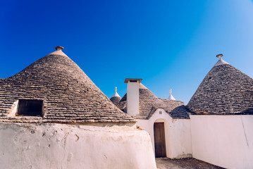 Fototapeta na wymiar Stone tiles cover the roofs of the trulli in Alberobello, an Italian city to visit on a trip to Italy.