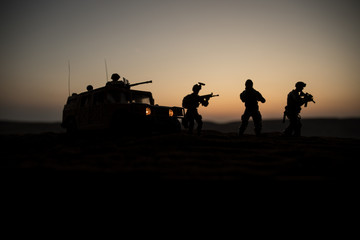Military patrol car on sunset background. Army war concept. Silhouette of armored vehicle with...