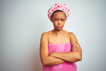 African american woman wearing pink shower towel after bath over isolated background skeptic and...