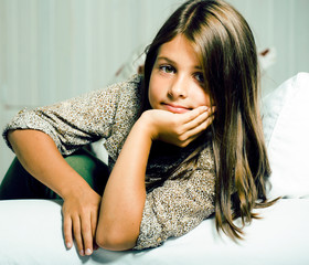 Naklejka premium little cute brunette girl at home interior happy smiling closeup, lifestyle real modern people concept