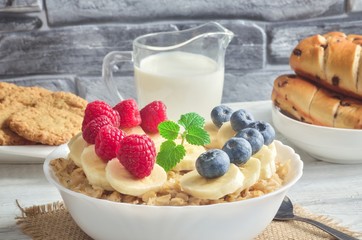 Delicious sweet healthy breakfast. Oatmeal with bananas, blueberries and raspberries.