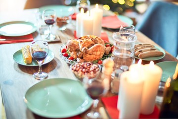 Setting of christmas table on festive holidays, full of traditional food with turky and delicious meals around the tree lights and decoration