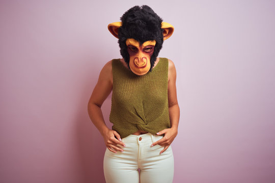 Woman standing wearing t-shirt and monkey mask