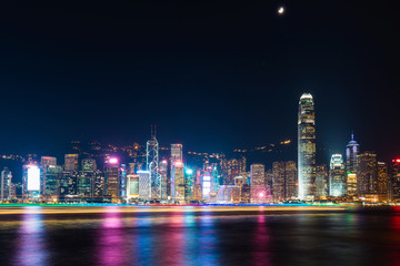 Hong Kong skyline at night with boat trails on the Victoria Harbour.