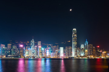 Victoria Harbour - Hong Kong skyline at night under the moonlight.