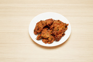 Deep fried fish paste balls served on white plate set on wooden