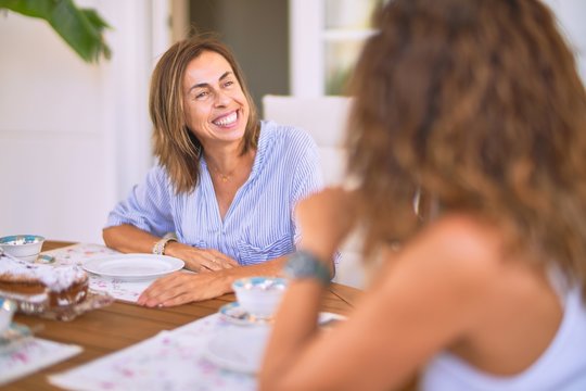 Young beautiful girl smiling happy and confident sitting dinking cup of coffee at terrace
