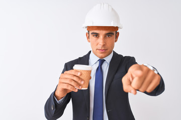 Young handsome architect man wearing helmet drinking coffee over isolated white background pointing with finger to the camera and to you, hand sign, positive and confident gesture from the front