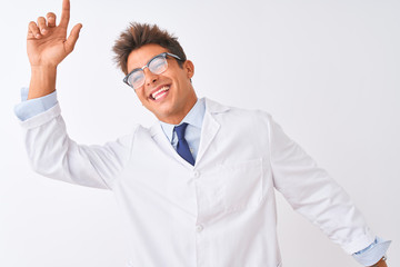 Young handsome sciencist man wearing glasses and coat over isolated white background Dancing happy and cheerful, smiling moving casual and confident listening to music