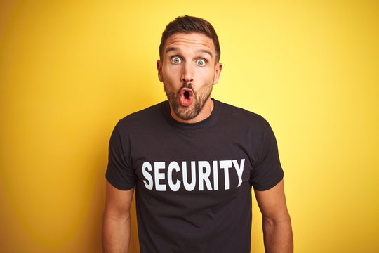 Young safeguard man wearing security uniform over yellow isolated background afraid and shocked with surprise expression, fear and excited face.