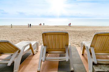 White beach chair on tropical beach with blue sky