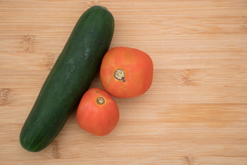 pepino y tomate sobre tabla tajados