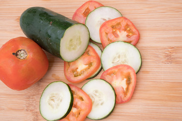pepino y tomate sobre tabla tajados