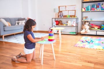 Beautiful toddler girl drawing cute draw using digital board at kindergarten