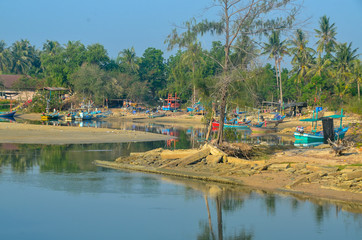 Naklejka premium Tropical vibrant coastal landscape waterscape with Thai fishing boat harbour. Huay Yang, Thailand.