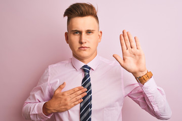 Young handsome businessman wearing shirt and tie standing over isolated pink background Swearing...
