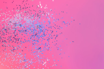 Bright colorful pink background with silver glitter confetti. Copy space