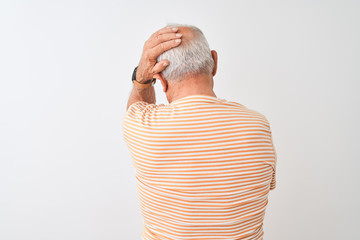 Senior grey-haired man wearing striped t-shirt standing over isolated white background Backwards...